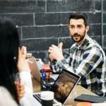 coworkers-discussing-while-sitting-desk-office_1048944-2596586