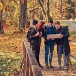 travel-hiking-adventure-concept-group-young-friends-hiking-autumn-colorful-forest-looking-map-planning-hike_613910-5532